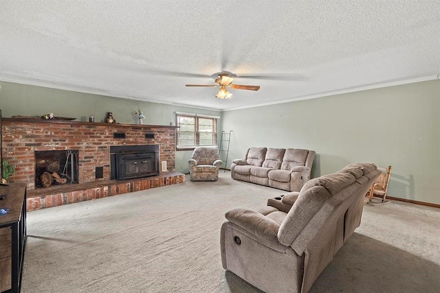 living room with a textured ceiling, carpet floors, a fireplace, ornamental molding, and ceiling fan