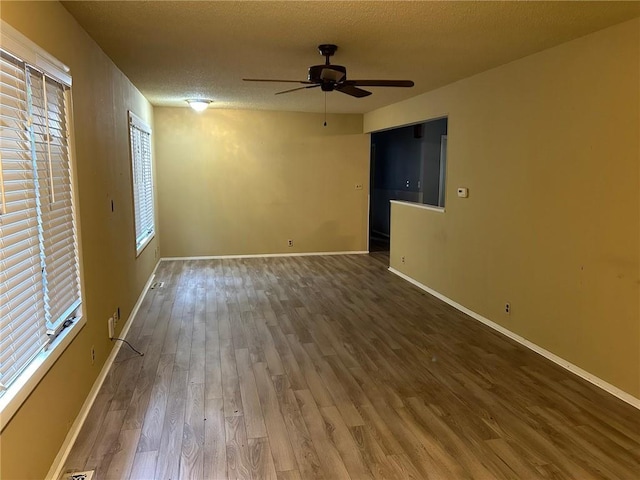 unfurnished room featuring ceiling fan, a textured ceiling, hardwood / wood-style floors, and a wealth of natural light