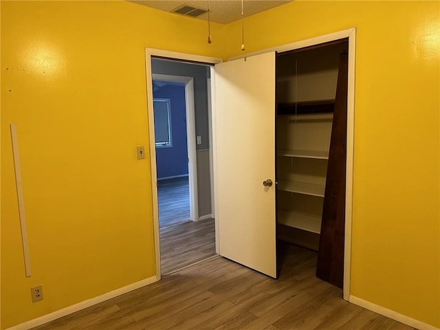 unfurnished bedroom with hardwood / wood-style flooring and a closet