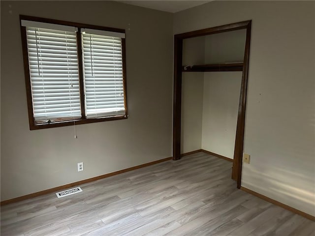 unfurnished bedroom with light hardwood / wood-style flooring and a closet