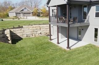 rear view of property with a yard, a patio, and a balcony