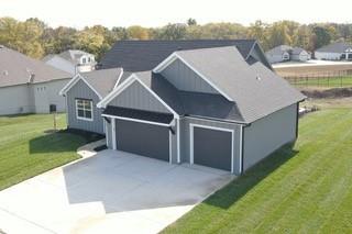 exterior space with an attached garage, driveway, and a front yard