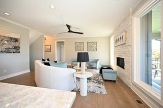 living room with ceiling fan, wood-type flooring, and a fireplace