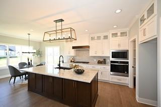 kitchen with dark wood-type flooring, white cabinetry, decorative light fixtures, and sink