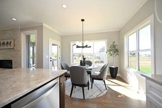 dining space with crown molding, wood-type flooring, and a fireplace