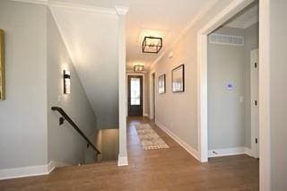 corridor featuring baseboards, wood finished floors, and an upstairs landing
