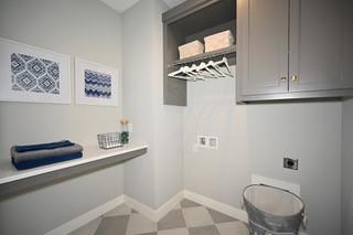laundry room with tile patterned floors, hookup for an electric dryer, baseboards, and cabinet space