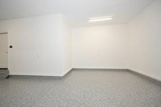 spare room with baseboards and speckled floor