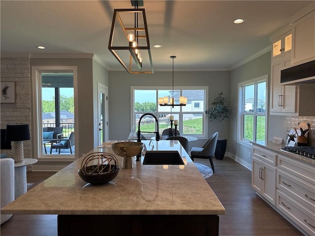 12850 N Arbor Way, Platte City, MO 64079 - kitchen with a chandelier, white cabinets, dark wood-style flooring, a center island with sink, and crown molding