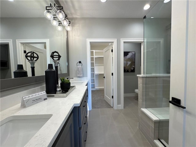 12850 N Arbor Way, Platte City, MO 64079 - full bath featuring double vanity, a shower with door, a walk in closet, tile patterned flooring, and recessed lighting