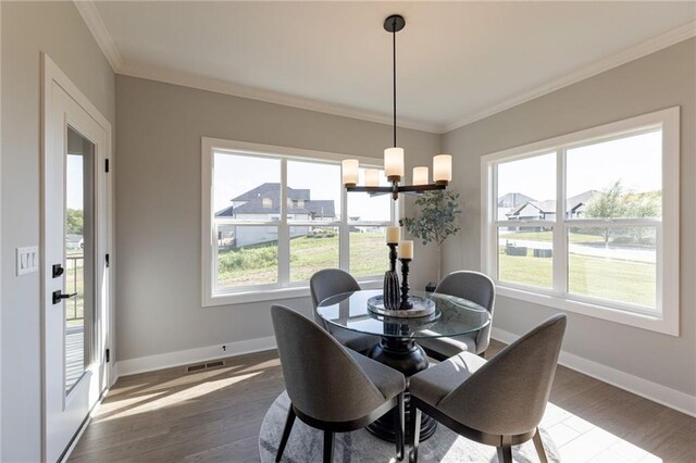 12850 N Arbor Way, Platte City, MO 64079 - dining space with healthy amount of natural light, dark wood-style floors, ornamental molding, and a chandelier