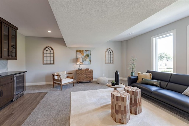 12850 N Arbor Way, Platte City, MO 64079 - living room featuring wine cooler, recessed lighting, a textured ceiling, light colored carpet, and light wood finished floors