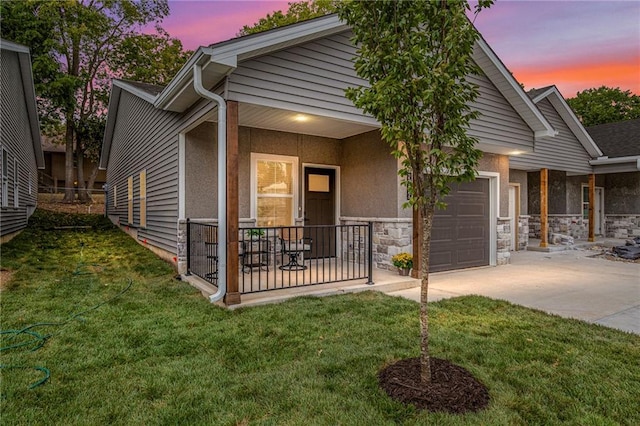 5826 Hunter Ct, Raytown, MO 64133 - view of front of property with an attached garage, driveway, a yard, stucco siding, and stone siding