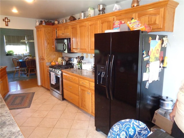 kitchen featuring black appliances, brown cabinetry, and light tile patterned flooring