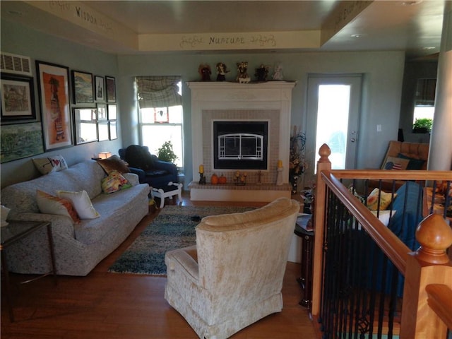 living area with plenty of natural light, visible vents, wood finished floors, and a glass covered fireplace