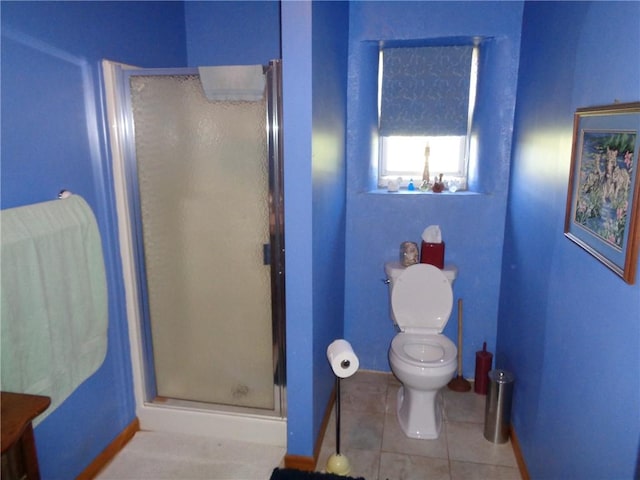 bathroom with toilet, a stall shower, tile patterned flooring, and baseboards