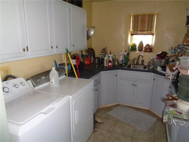 washroom with independent washer and dryer, cabinet space, a sink, and light tile patterned floors