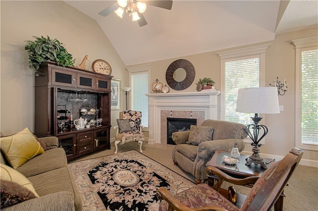 carpeted living room with lofted ceiling, a tiled fireplace, ceiling fan, and plenty of natural light