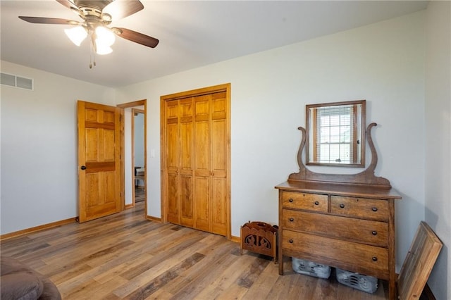 bedroom featuring light hardwood / wood-style floors, ceiling fan, and a closet