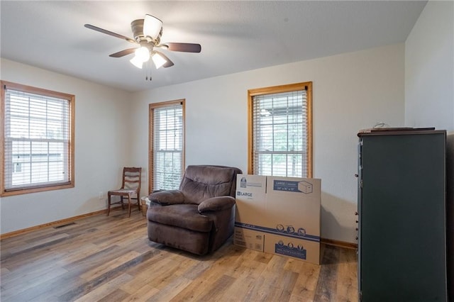 sitting room featuring wood-type flooring and ceiling fan