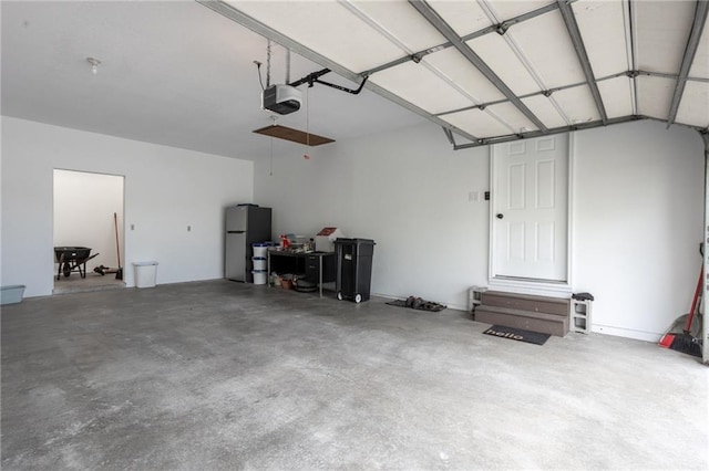 garage featuring a garage door opener and stainless steel refrigerator