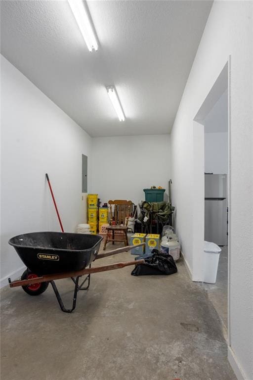 garage with stainless steel refrigerator and electric panel