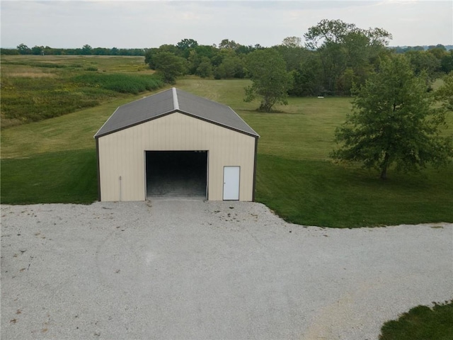 garage with a rural view and a yard