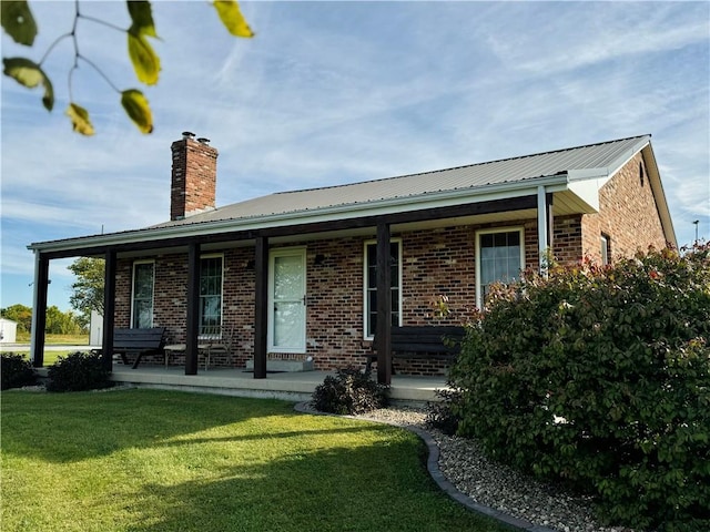 back of property featuring a lawn and covered porch