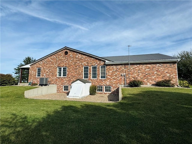 rear view of house featuring a lawn and central air condition unit