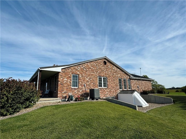 rear view of property featuring central AC and a yard