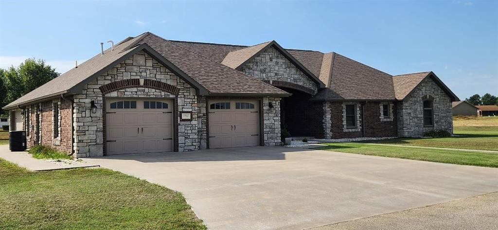 french country inspired facade featuring a garage and a front yard