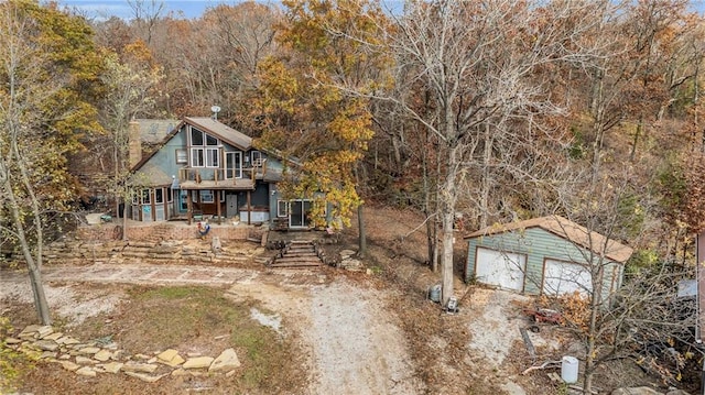 rustic home with a detached garage and an outdoor structure