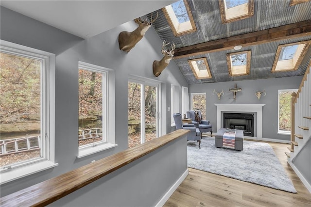 sunroom with lofted ceiling with skylight and a fireplace