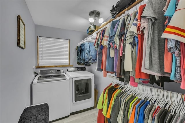 interior space with laundry area, independent washer and dryer, and wood finished floors