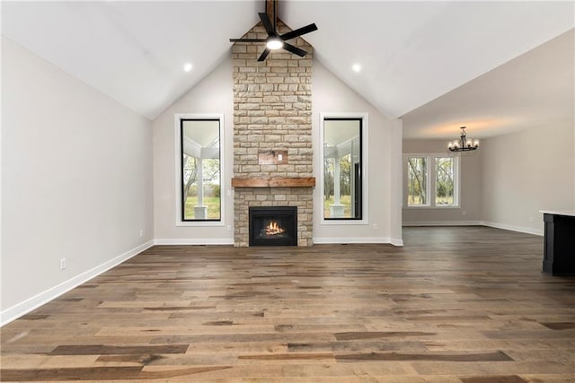 unfurnished living room featuring a fireplace, wood-type flooring, plenty of natural light, and lofted ceiling