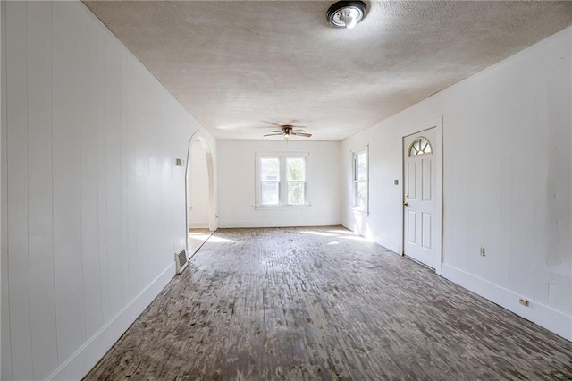 unfurnished living room featuring ceiling fan, hardwood / wood-style floors, and a textured ceiling