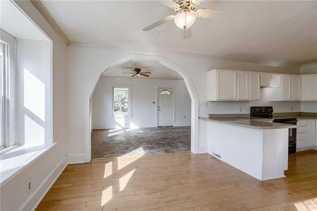 kitchen with light hardwood / wood-style floors, electric range, kitchen peninsula, ornamental molding, and white cabinets