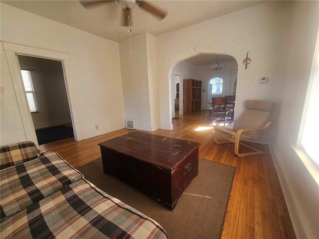 living room featuring hardwood / wood-style floors and ceiling fan with notable chandelier