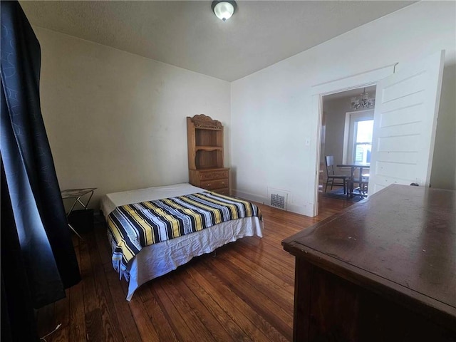 bedroom featuring dark hardwood / wood-style flooring and a notable chandelier