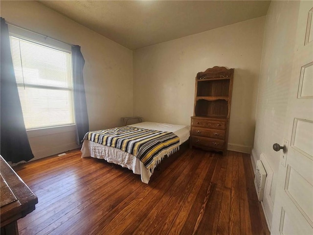 bedroom with dark wood-type flooring