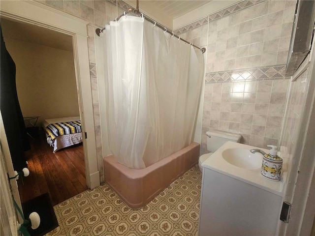 full bathroom featuring hardwood / wood-style floors, vanity, shower / tub combo, and tile walls