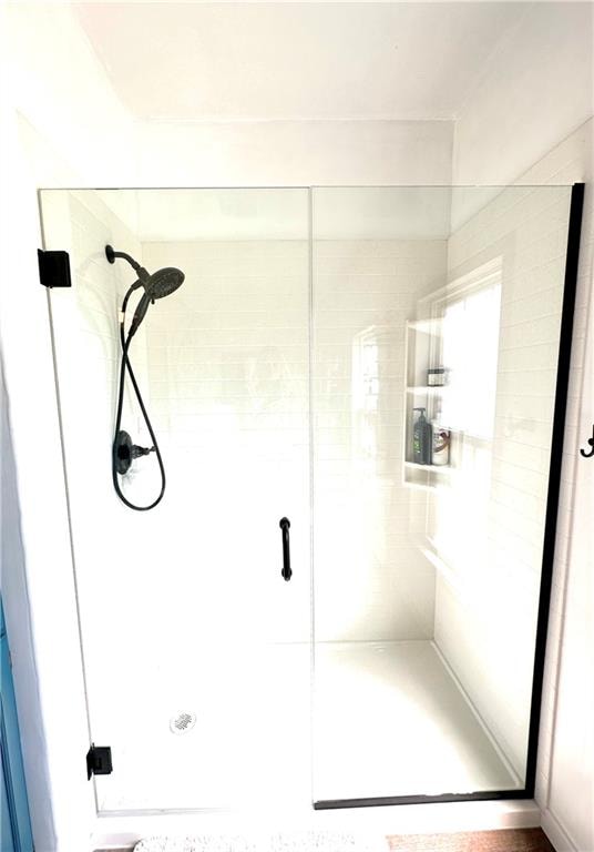 bathroom featuring a shower with shower door