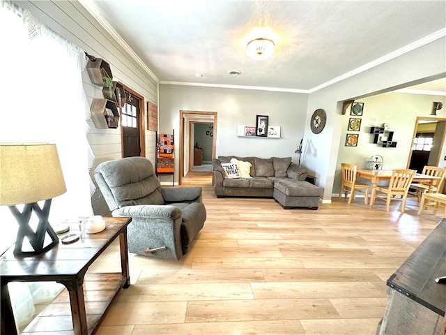 living room with light wood-type flooring and ornamental molding