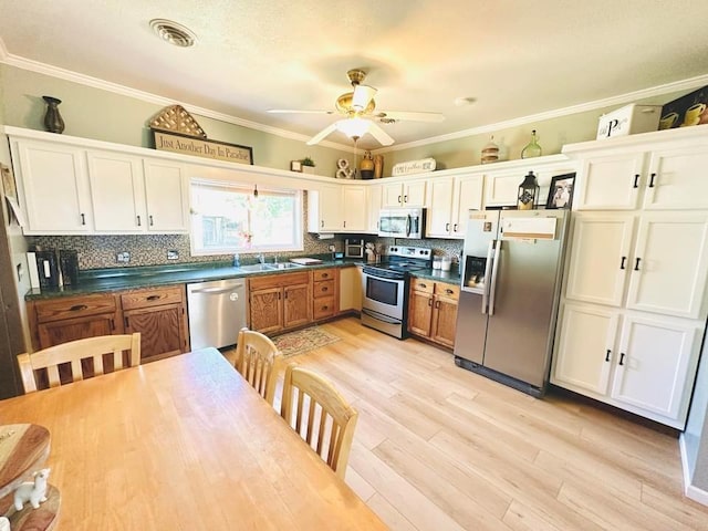 kitchen with ceiling fan, stainless steel appliances, and white cabinetry