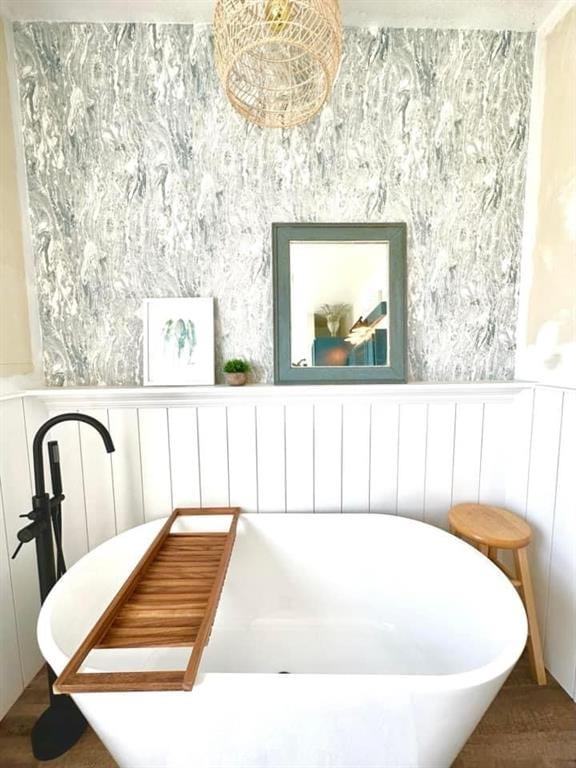 interior space with a tub to relax in and hardwood / wood-style flooring