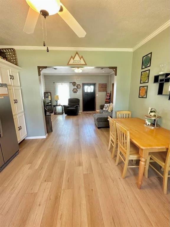 dining room with ceiling fan, crown molding, and light hardwood / wood-style floors