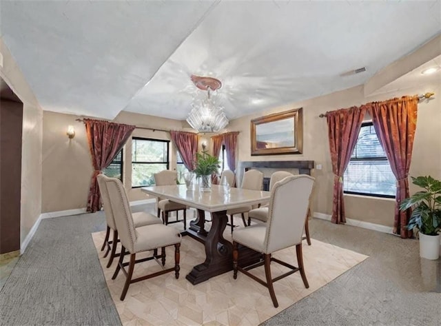 dining space featuring lofted ceiling, a wealth of natural light, and an inviting chandelier