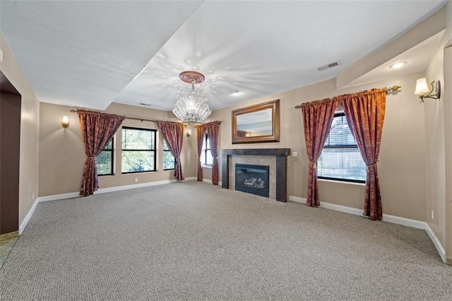 unfurnished living room featuring plenty of natural light, a tile fireplace, and carpet