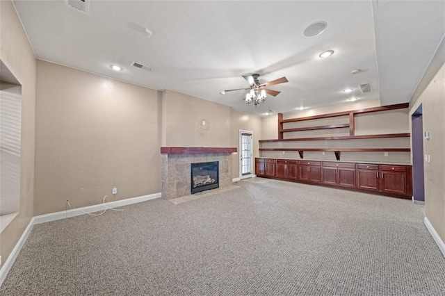 unfurnished living room with a fireplace, light colored carpet, and ceiling fan