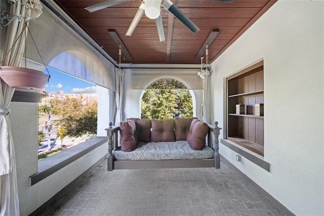 sunroom with wooden ceiling and ceiling fan